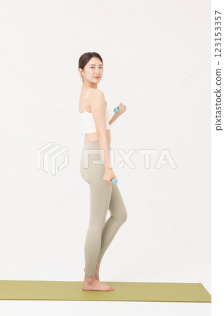 Portrait of a young woman doing bodyweight exercises while holding dumbbells Portrait of a young woman doing bodyweight exercises while holding dumbbells 123153357