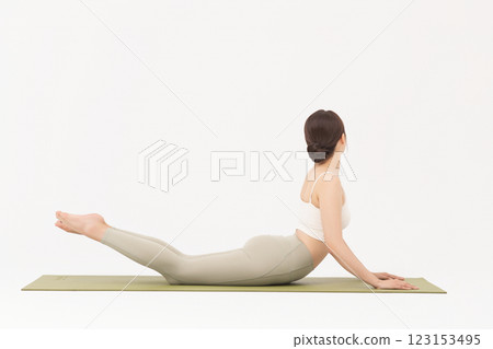 Portrait of a young woman wearing sportswear and doing yoga on a yoga mat 123153495