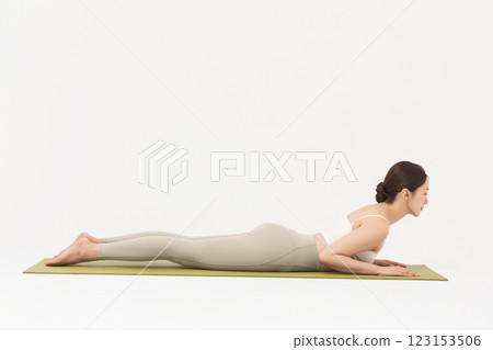 Portrait of a young woman wearing sportswear and doing yoga on a yoga mat Portrait of a young woman wearing sportswear and doing yoga on a yoga mat 123153506