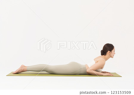 Portrait of a young woman wearing sportswear and doing yoga on a yoga mat 123153509