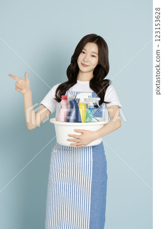 A woman in her 20s holding a basin containing cleaning tools for cleaning A woman in her 20s holding a basin containing cleaning tools for cleaning 123153628