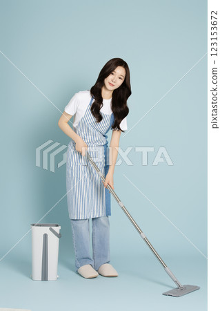 A woman in her 20s mopping the floor with a gunny mop 123153672