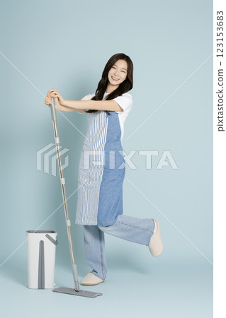 A woman in her 20s mopping the floor with a gunny mop 123153683