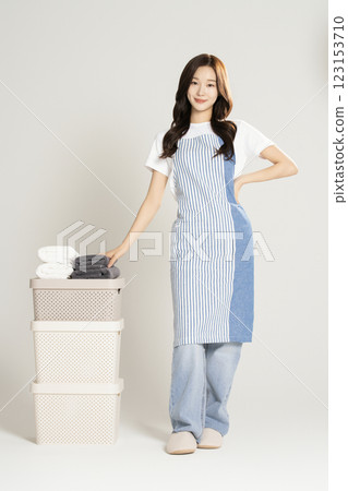 A woman in her 20s standing next to a living box and towel 123153710