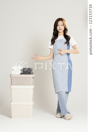 A woman in her 20s standing next to a living box and towel A woman in her 20s standing next to a living box and towel 123153716