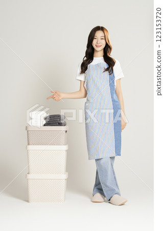 A woman in her 20s standing next to a living box and towel 123153720