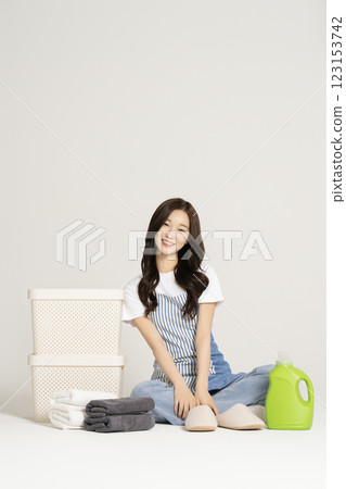 A woman in her 20s sitting next to a living box and organizing towels A woman in her 20s sitting next to a living box and organizing towels 123153742