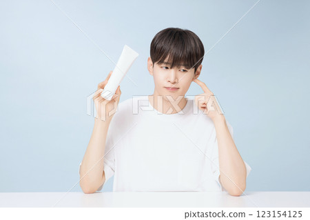 A young man demonstrating basic men's cosmetics A young man demonstrating basic men's cosmetics 123154125