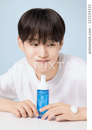 A young man demonstrating basic men's cosmetics A young man demonstrating basic men's cosmetics 123154322