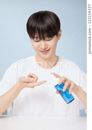 A young man demonstrating basic men's cosmetics A young man demonstrating basic men's cosmetics 123154337
