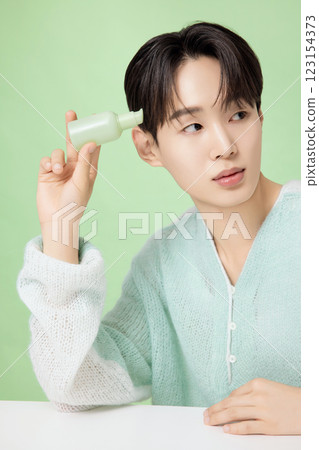 A man in his 20s posing with green essence A man in his 20s posing with green essence 123154373