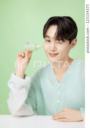 A man in his 20s posing with green essence A man in his 20s posing with green essence 123154375