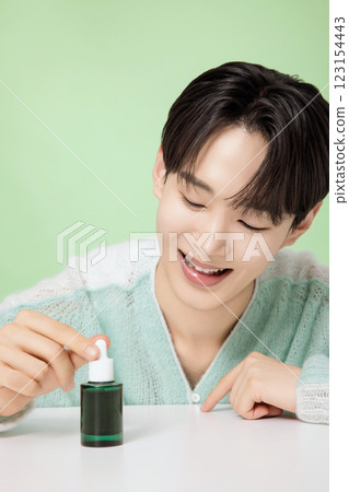 A man in his 20s posing with green essence 123154443