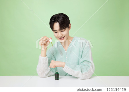 A man in his 20s posing with green essence 123154459