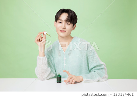 A man in his 20s posing with green essence A man in his 20s posing with green essence 123154461