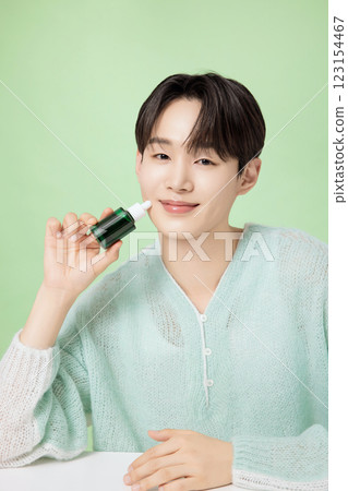 A man in his 20s posing with green essence 123154467