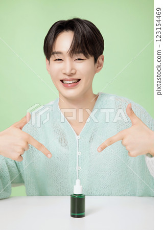 A man in his 20s posing with green essence 123154469