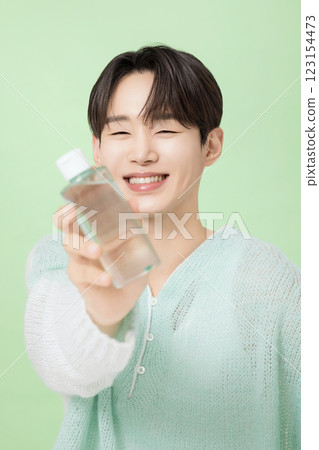 A man in his 20s posing with green essence A man in his 20s posing with green essence 123154473
