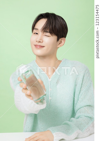 A man in his 20s posing with green essence 123154475