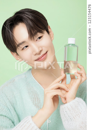 A man in his 20s posing with green essence 123154476