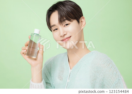 A man in his 20s posing with green essence A man in his 20s posing with green essence 123154484