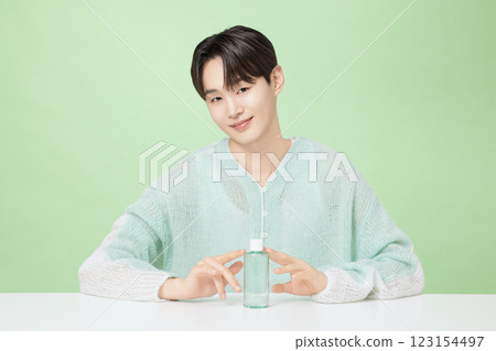 A man in his 20s posing with green essence A man in his 20s posing with green essence 123154497