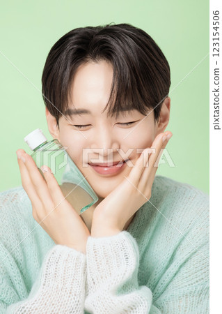 A man in his 20s posing with green essence 123154506