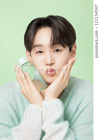 A man in his 20s posing with green essence 123154507