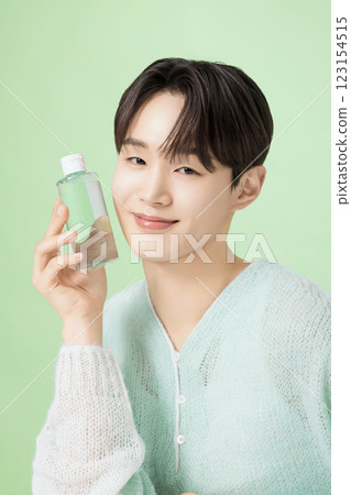 A man in his 20s posing with green essence A man in his 20s posing with green essence 123154515