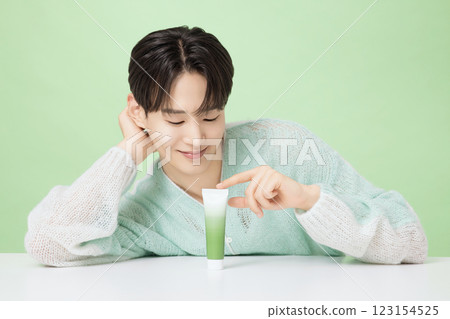 A man in his 20s posing with green essence 123154525