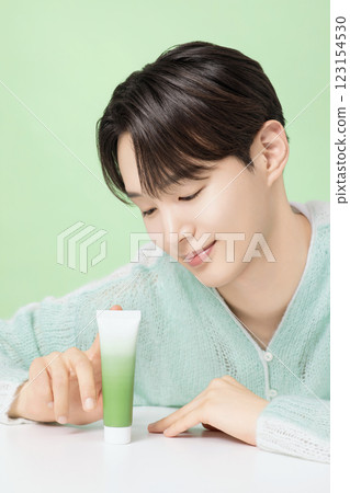 A man in his 20s posing with green essence 123154530