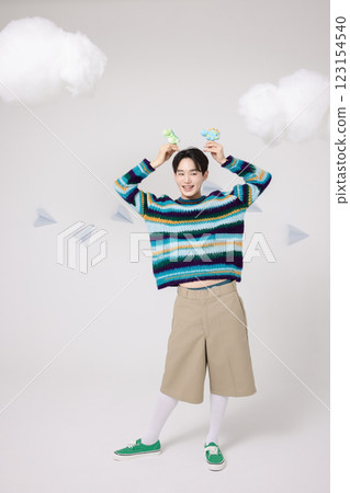 Portrait of man holding dinosaur candy in clouds 123154540