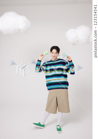 Portrait of man holding dinosaur candy in clouds 123154541