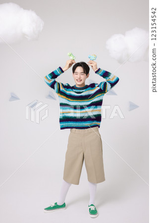 Portrait of man holding dinosaur candy in clouds 123154542