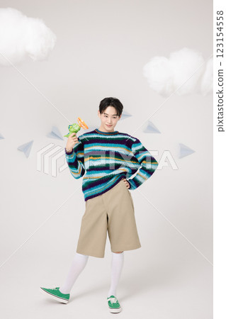Cropped view of man standing in clouds holding toy bubble gun 123154558