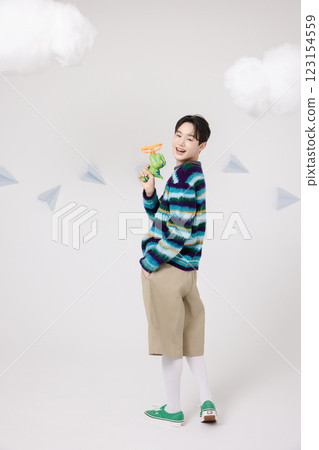 Cropped view of man standing in clouds holding toy bubble gun 123154559