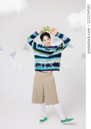 Cropped view of man standing in clouds holding toy bubble gun 123154561