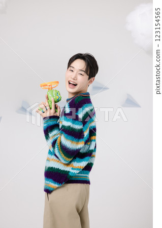 Cropped view of man standing in clouds holding toy bubble gun 123154565