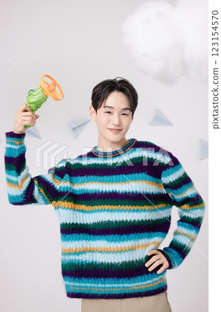 Cropped view of man standing in clouds holding toy bubble gun 123154570
