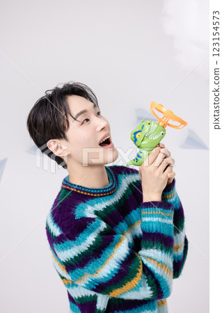 Cropped view of man standing in clouds holding toy bubble gun 123154573