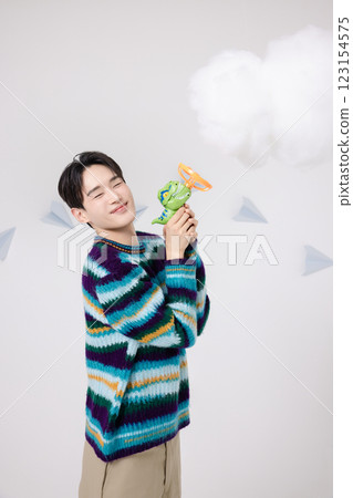 Cropped view of man standing in clouds holding toy bubble gun 123154575
