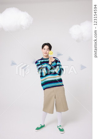 Portrait of a man standing in the clouds holding candy Portrait of a man standing in the clouds holding candy 123154594