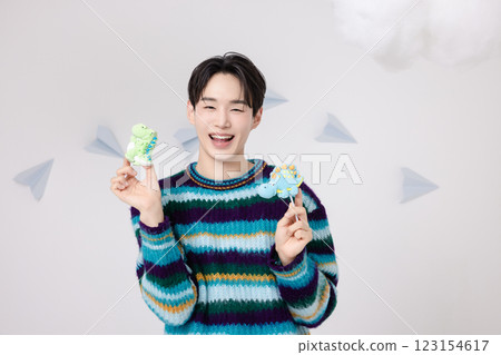 Portrait of a man standing in the clouds holding candy Portrait of a man standing in the clouds holding candy 123154617
