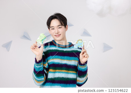 Portrait of a man standing in the clouds holding candy 123154622