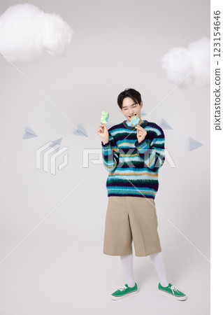 Portrait of a man standing in the clouds holding candy 123154646
