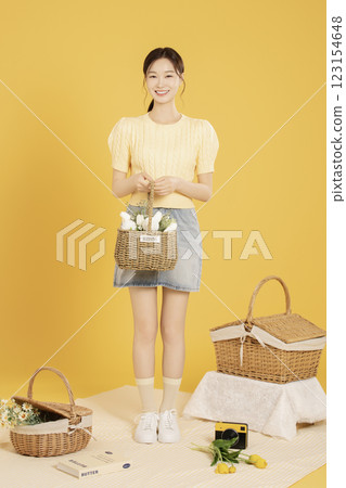 A woman in her 20s spreading out a mat and enjoying a picnic 123154648