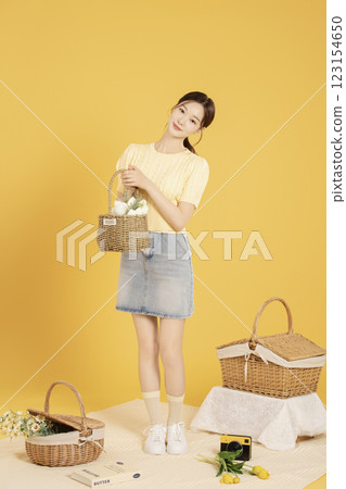 A woman in her 20s spreading out a mat and enjoying a picnic 123154650