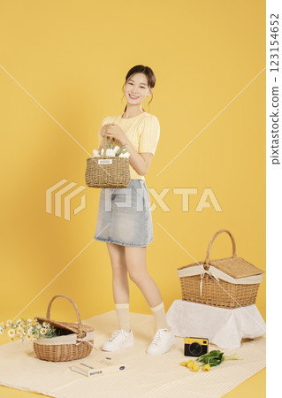 A woman in her 20s spreading out a mat and enjoying a picnic 123154652