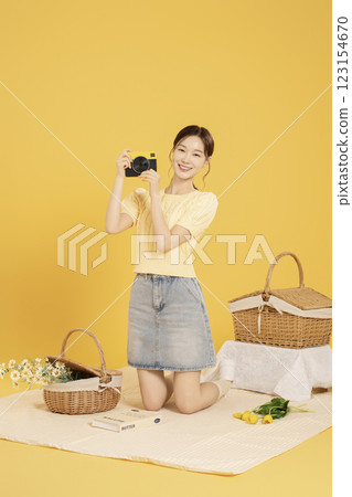 A woman in her 20s spreading out a mat and enjoying a picnic 123154670