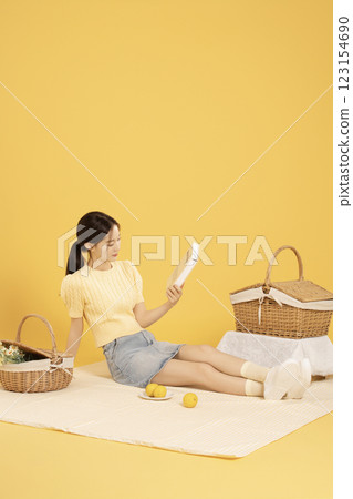 A woman in her 20s spreading out a mat and enjoying a picnic A woman in her 20s spreading out a mat and enjoying a picnic 123154690